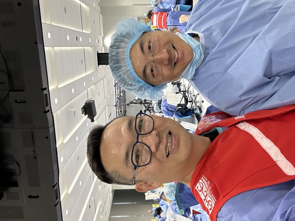 Dr. Ahn and Dr. Au in scrubs at a packed cadaver lab